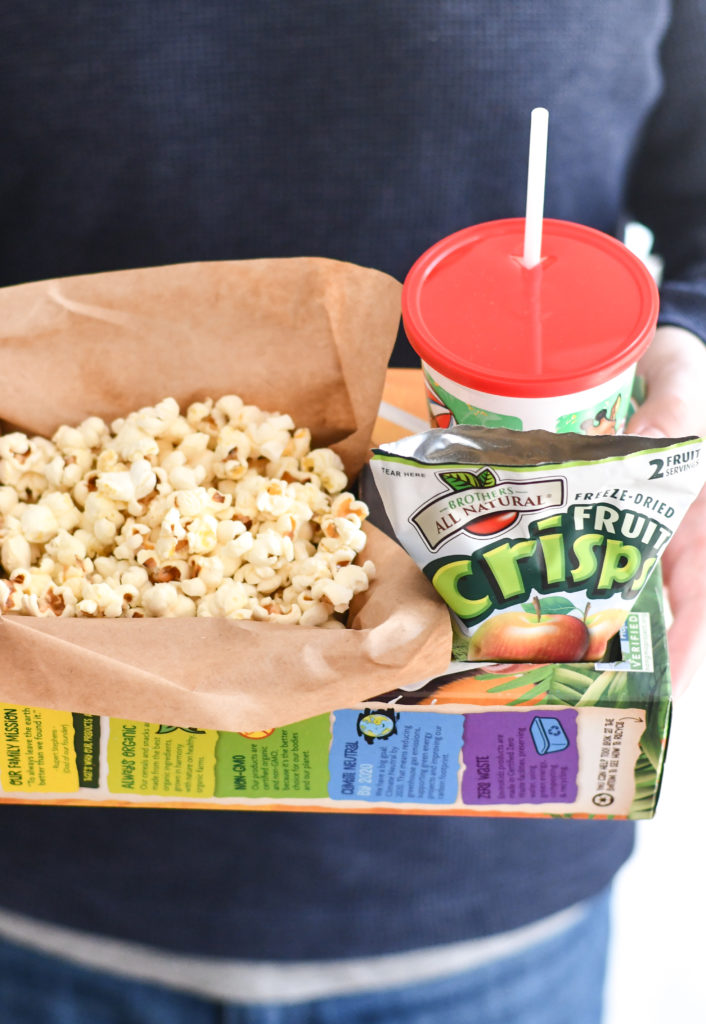 Hands holding a DIY Popcorn Box with a drink and snack