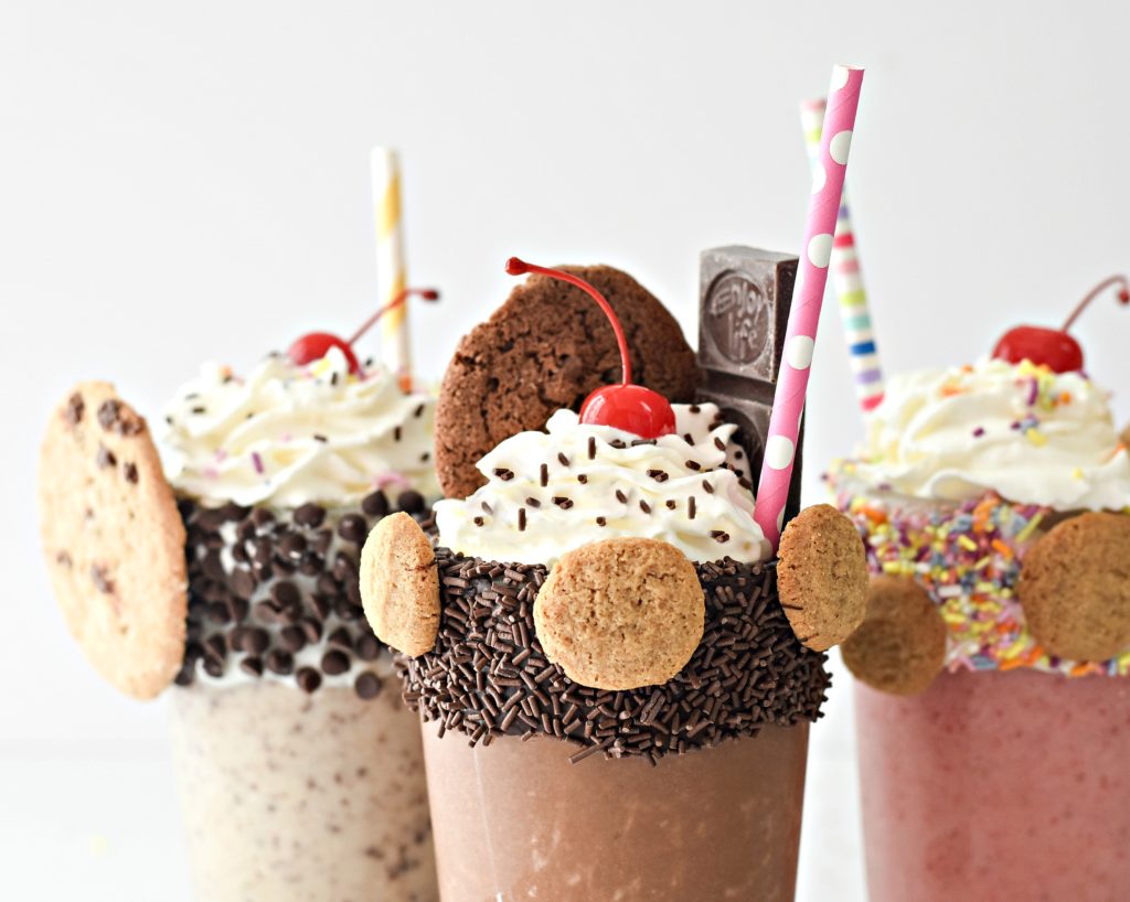 Glasses of milkshakes made from bananas with whipped cream and sprinkles