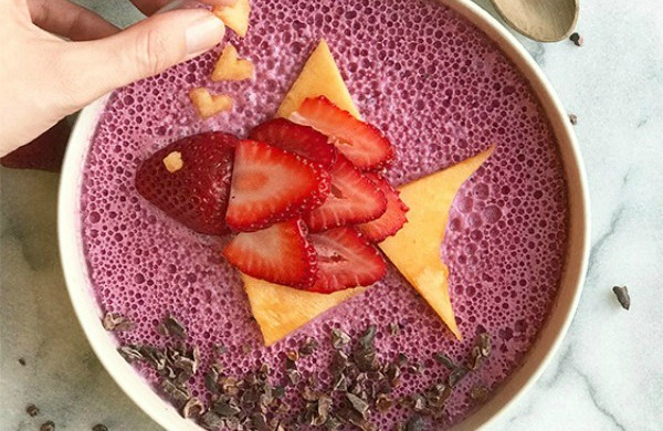 A smoothie bowl with a strawberry fish on top