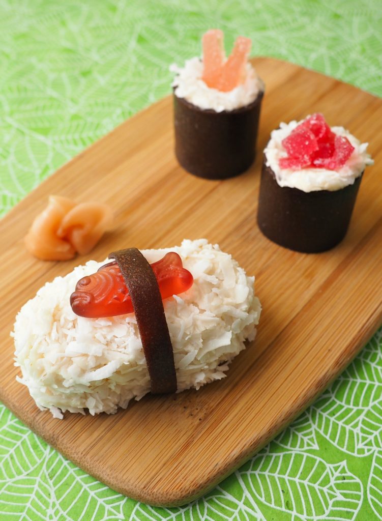 A cutting board with Cake Sushi on top made with cake, fruit leather, and gummy candies