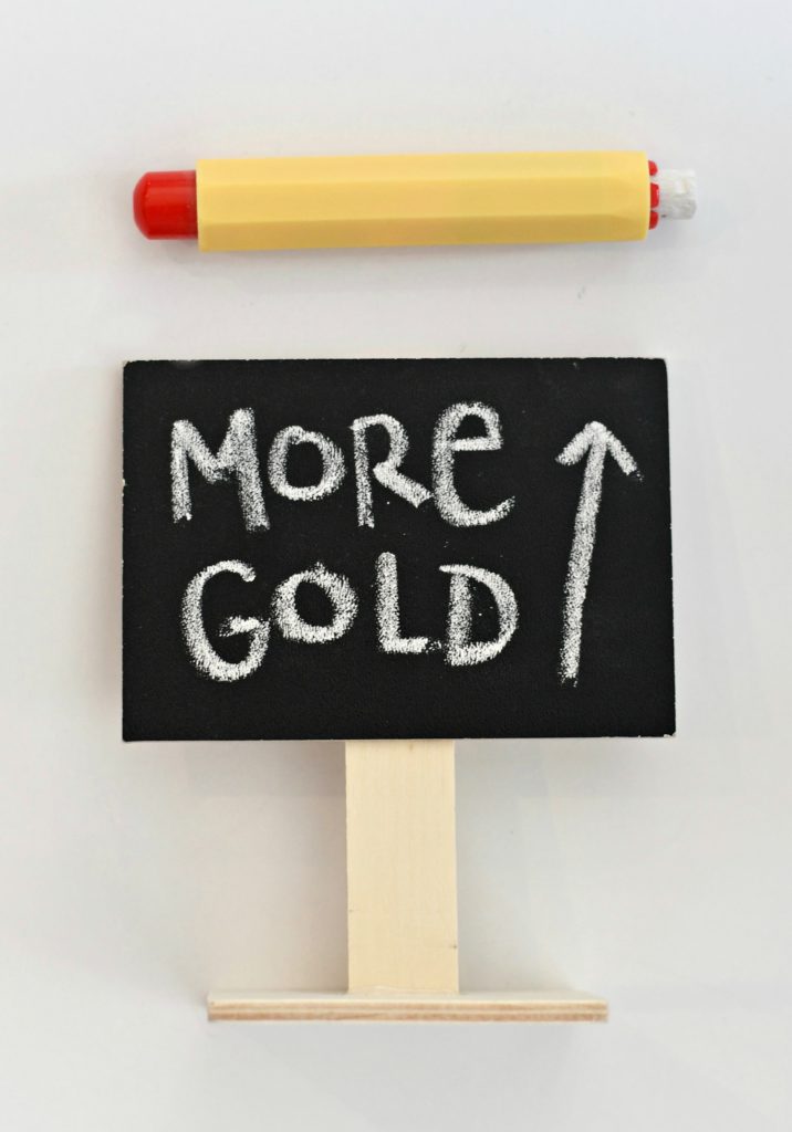 A mini chalkboard sign that says "More gold" with an up arrow