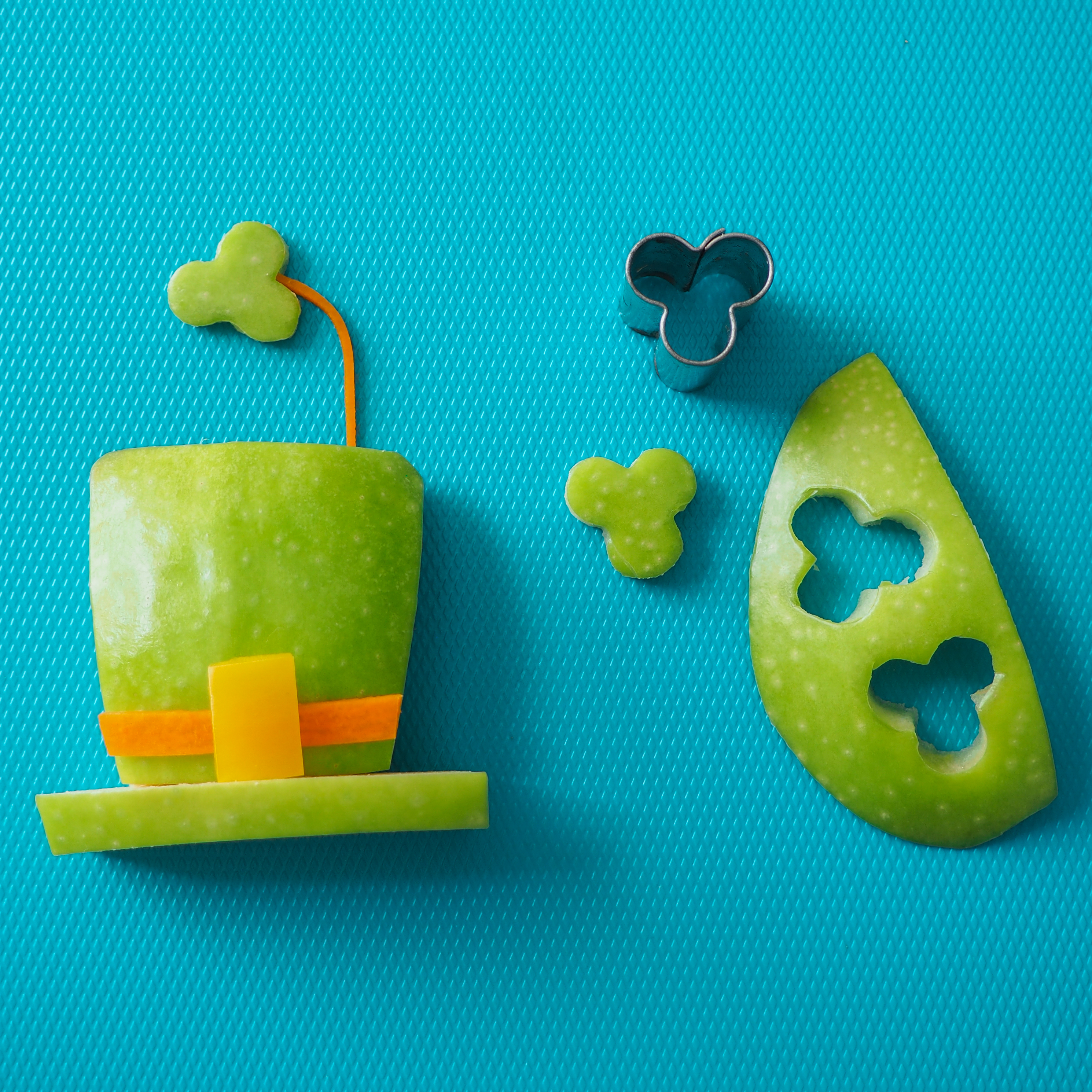 A teal background with a how-to on making Leprechaun Apple Hats