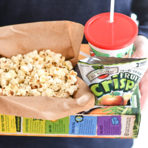 Hands holding a DIY Popcorn Box with a drink and snack