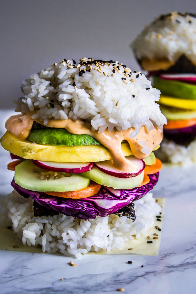 Get your kids involved with piling on the veggies on these Rainbow Sushi Burgers for a perfect meatless meal that all can participate in making & will love! #veganrecipes #kidfood #sushi #dinner