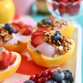 A white background with yogurt apple bowls topped with fresh fruit and granola