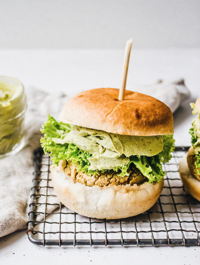 A white background with 2 falafel burgers and avocado cream.